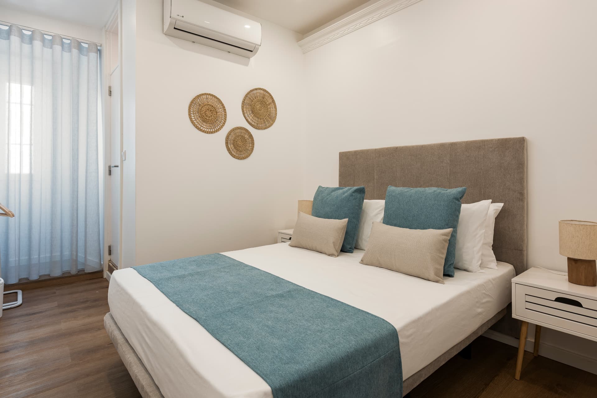 Suite dupla do Madalena, com cama de casal, almofadas azuis e decoração de fibras naturais